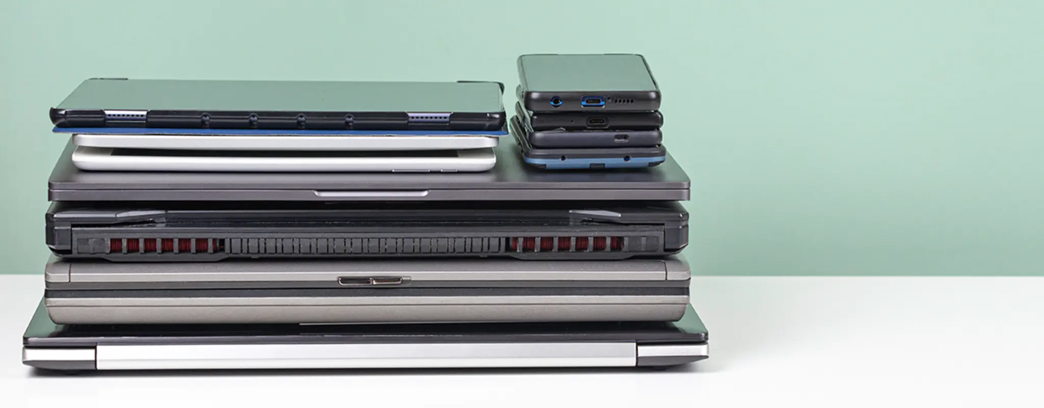 Ein akkurater Stapel aus Laptops, Tablets und Handys 