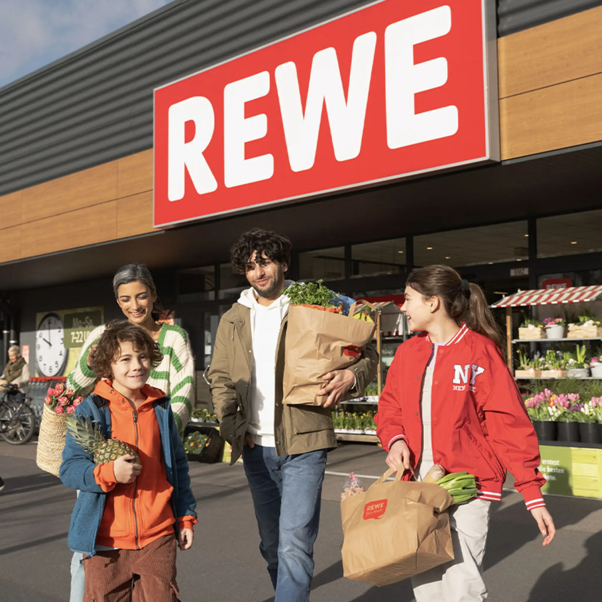 Eine Familie kauft in einem REWE Markt ein.
