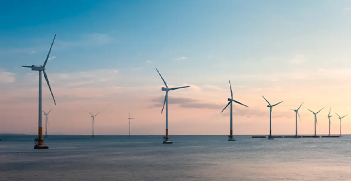 Ein Offshore-Windpark: Mehrere weiße Windräder stehen im Ozean.