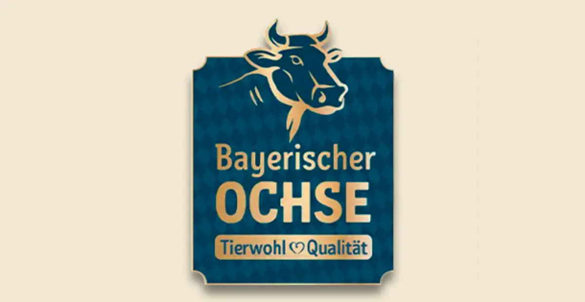 Das blaue Logo mit der Aufschrift „Bayerischer Ochse. Tierwohl & Regionalität.“ zeigt einen illustrierten Ochsen. 