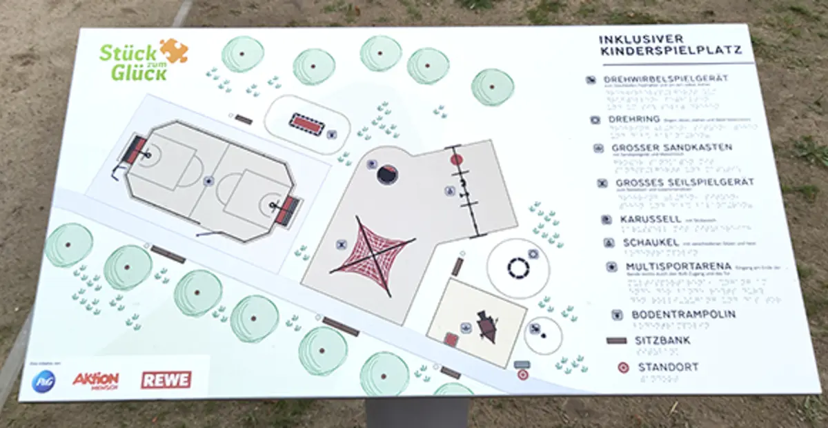Ein taktiles Spielplatzschild auf einem inklusiven Spielplatz.