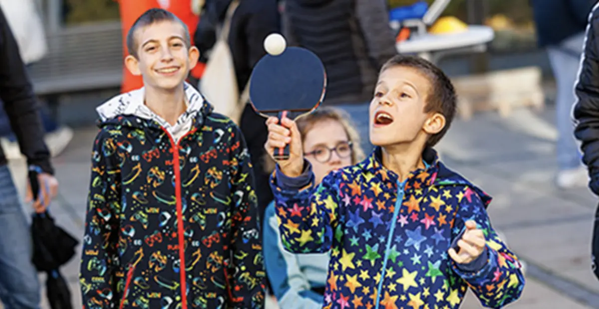 Kinder mit und ohne Behinderung spielen bei einem Event des Inklusionsmobils gemeinsam Tischtennis. 