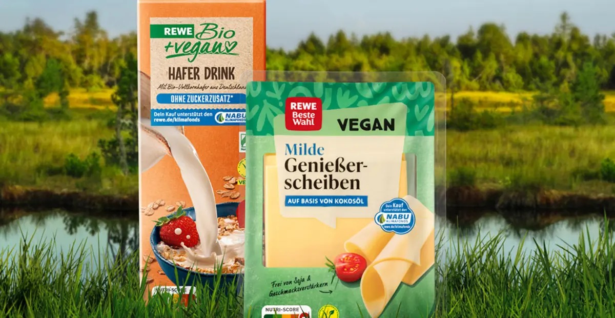 Eine Packung REWE Bio + vegan Hafer Drink und eine Packung REWE Beste Wahl Milde Genießerscheiben vegan vor einem naturbelassenen Moor im Hintergrund.