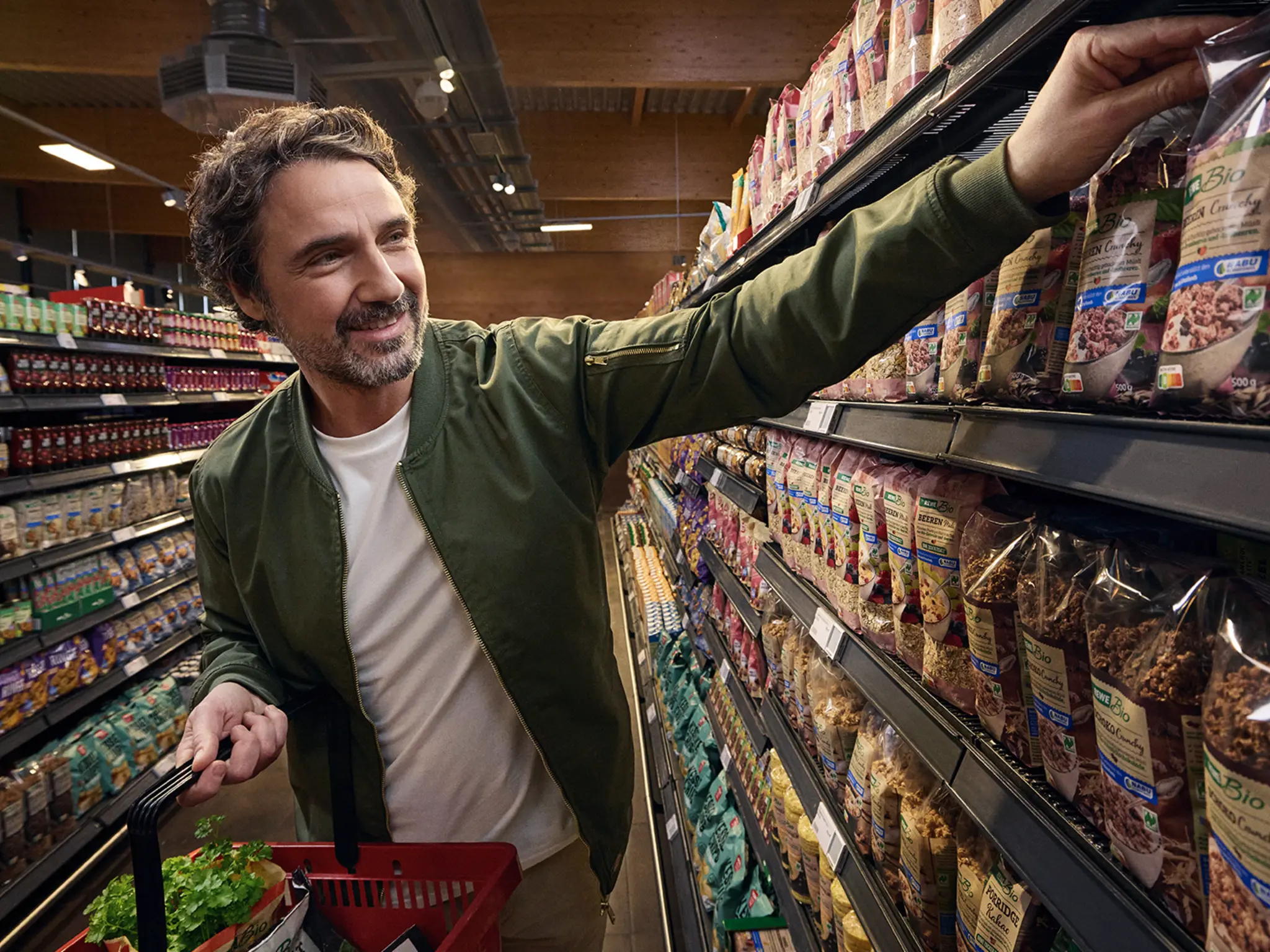 Eine Person greift im REWE Markt zu nachhaltigeren Produkten.