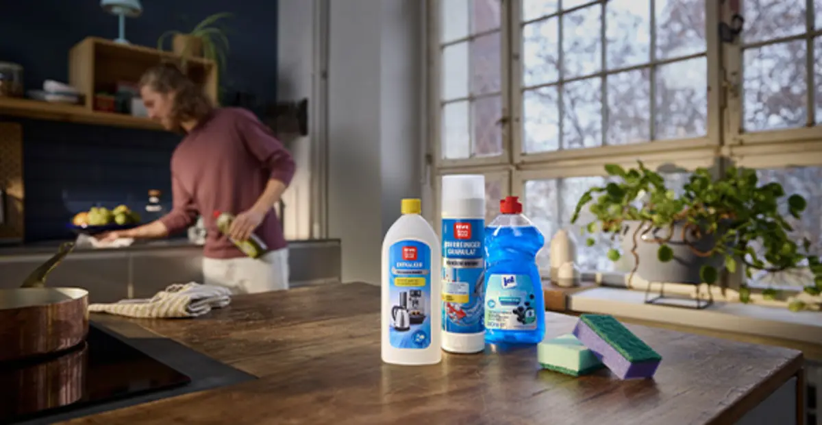 Drei REWE Eigenmarken-Putzmittel stehen auf einem Küchentresen. Die Verpackungen sind aus Recylat.
