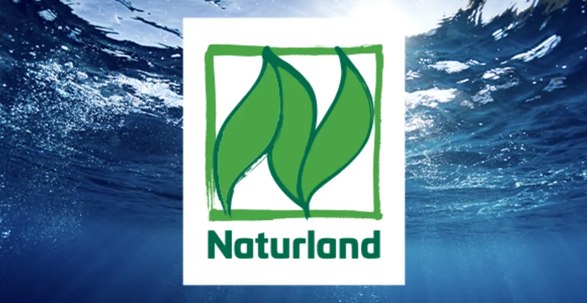 Das Naturland Siegel vor einem Meer im Hintergrund.