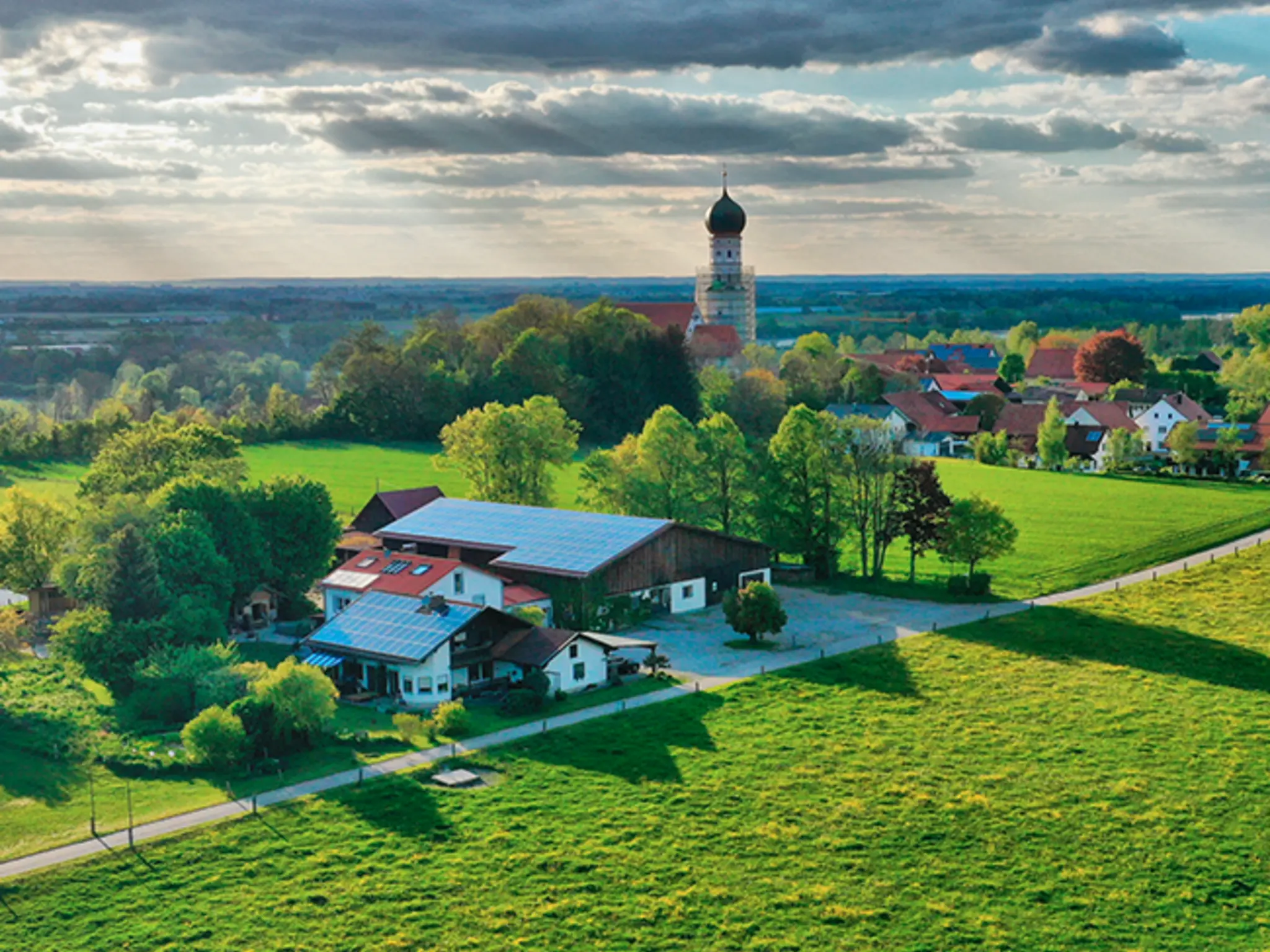 Der Jegglhof inmitten von Bäumen und Weiden.