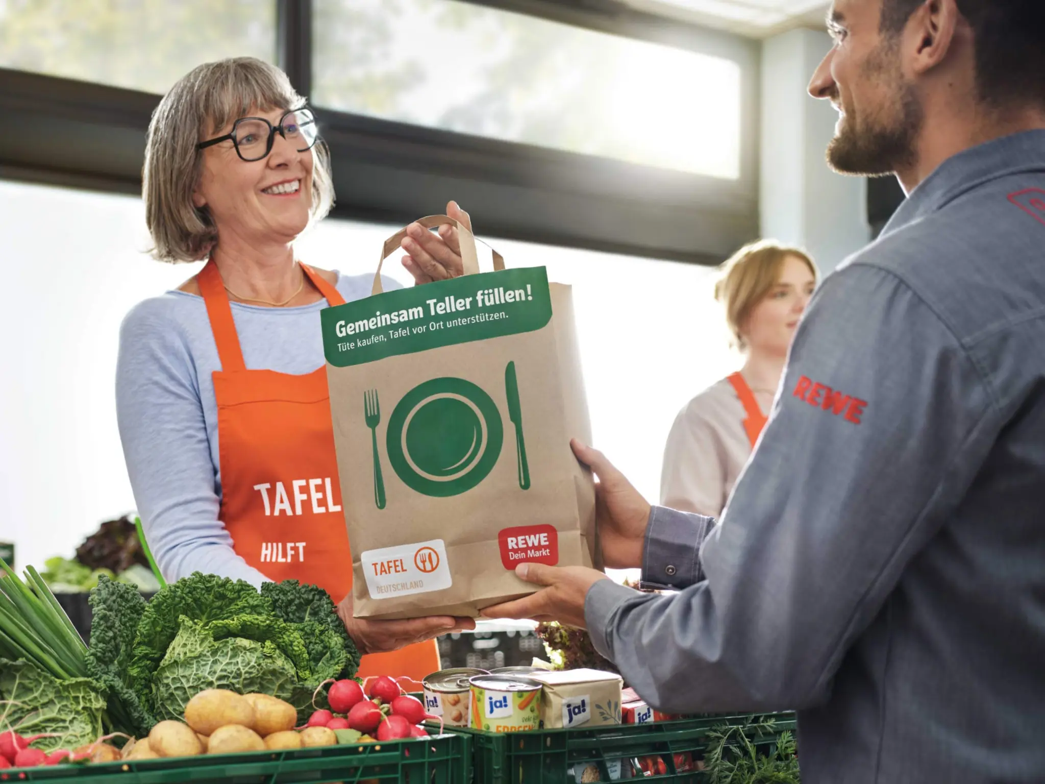Ein REWE Mitarbeiter liefert Lebensmittel bei der Tafel ab.