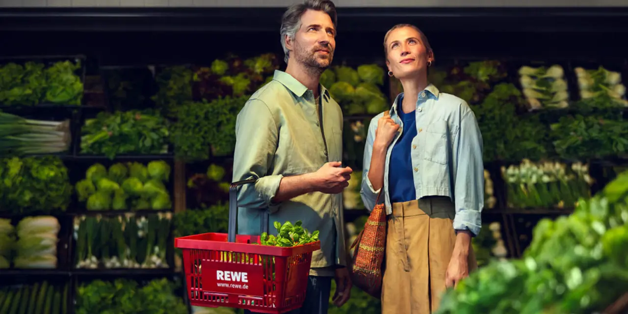 Zwei REWE Kund:innen beim nachhaltigeren Einkauf im REWE Markt. 