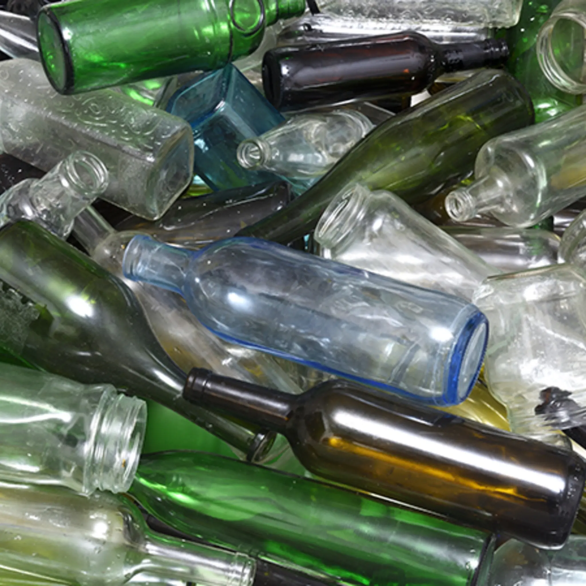 Eine Ansammlung aus leeren Glasflaschen in verschiedenen Farben 