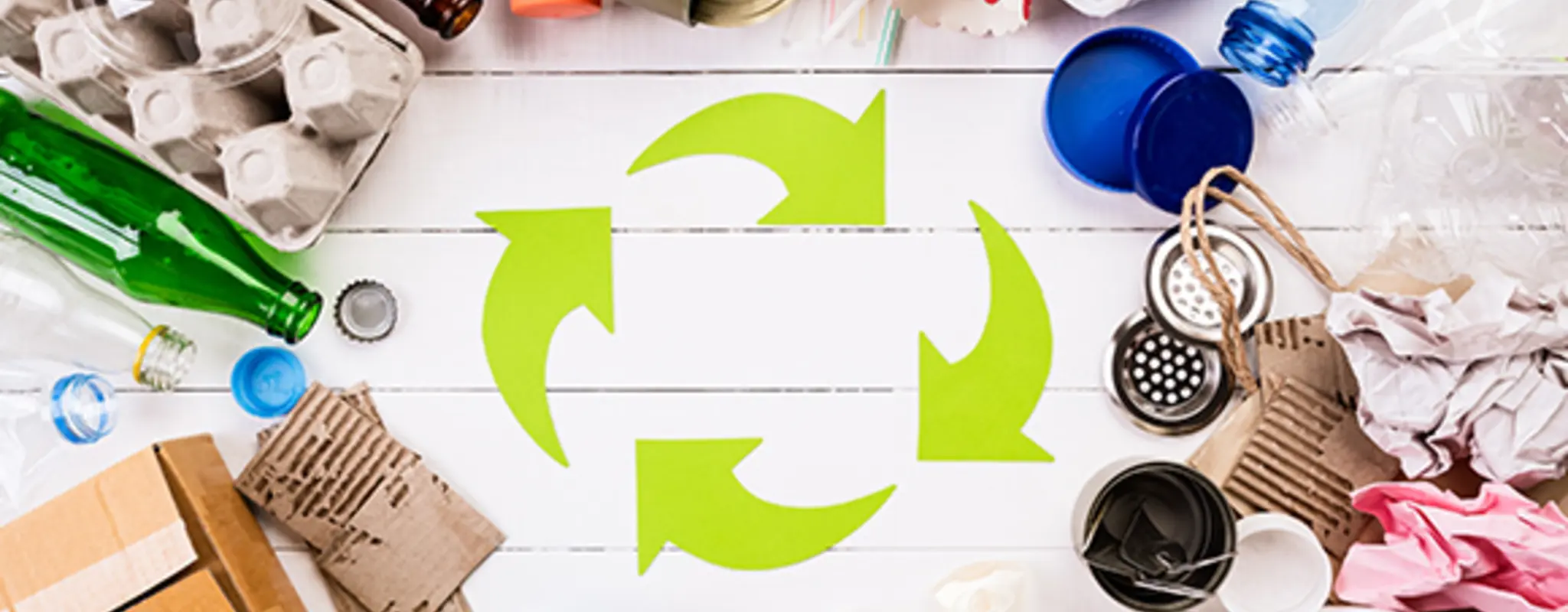 Grünes Recyclingsymbol aus Pfeilen, die einen Kreislauf bilden, umringt von Abfallprodukten aus Plastik, Glas, Papier und Metall