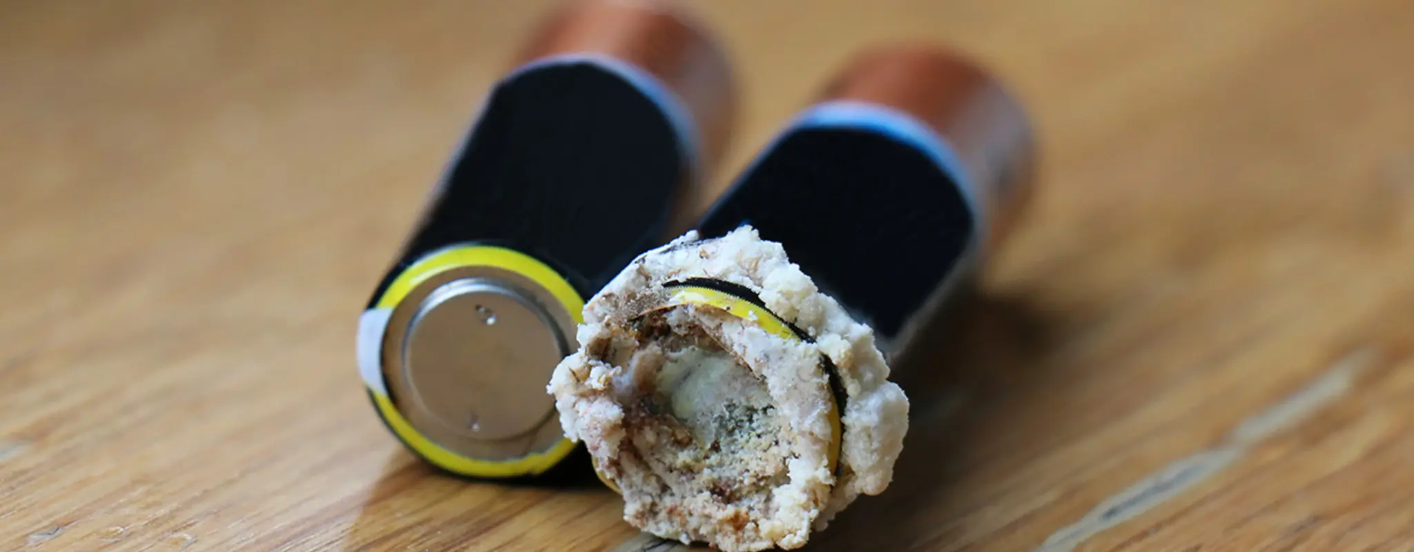 Eine intakte Batterie neben einer ausgelaufenen Batterie