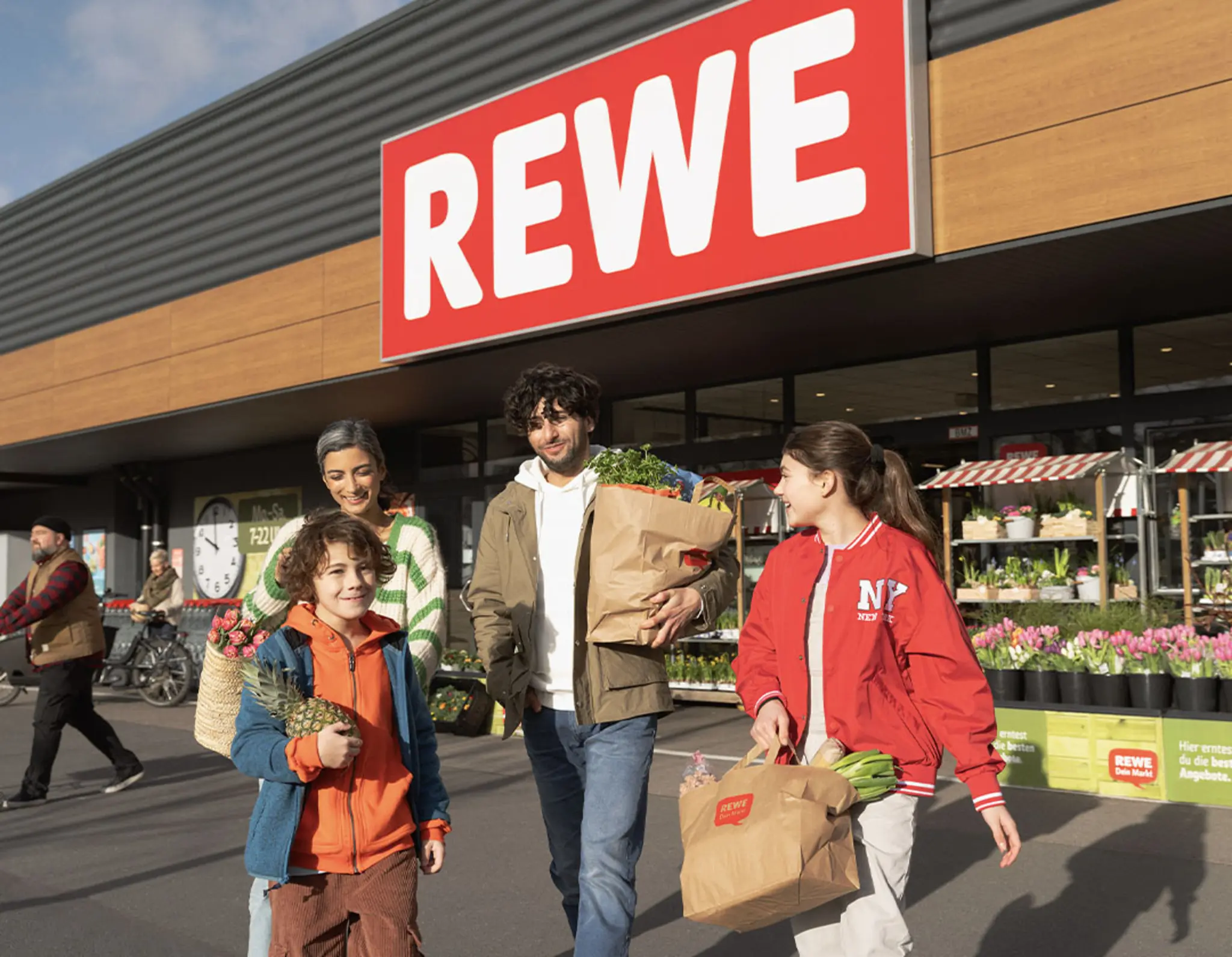 Eine Familie kauft in einem REWE Markt ein.
