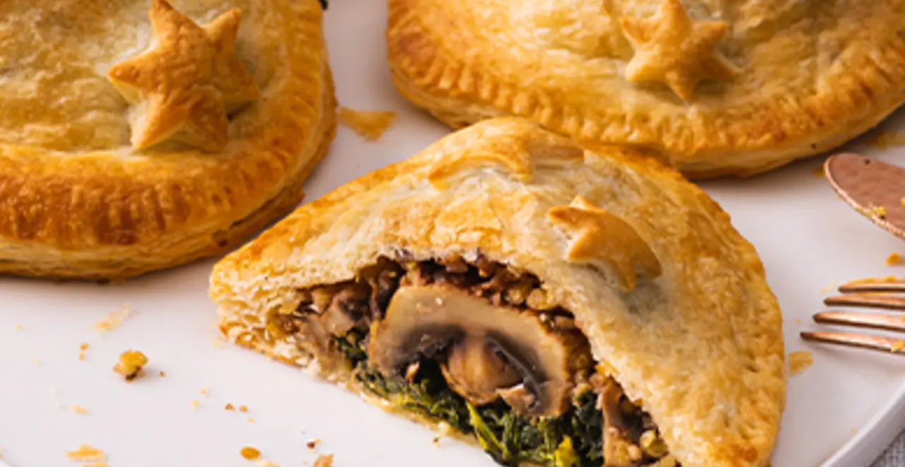 4 knusprige Stücke veganer Braten im Blätterteigmantel liegen auf einem Teller.