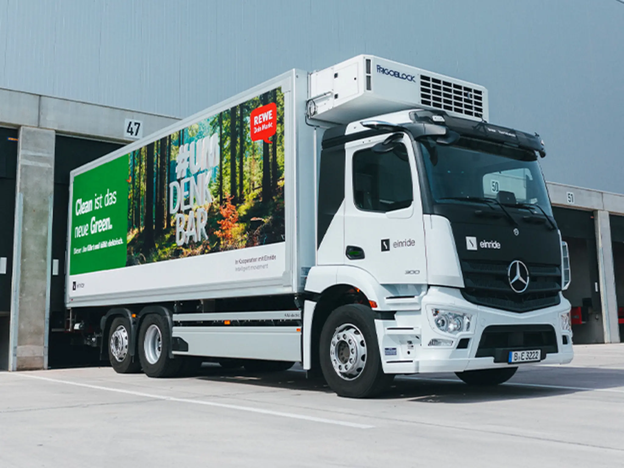 Ein E-Lkw des Transportunternehmens Einride. Auf der Seite sieht man REWE Werbung mit dem Text „Clean ist das neue Green. #UMDENKBAR“.
