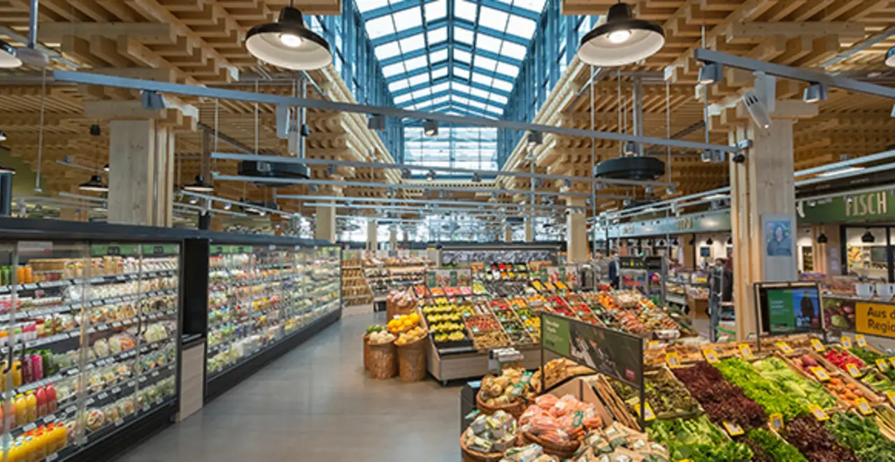 Der REWE Green Farming Markt in Wiesbaden-Erbenheim von innen. Man erkennt das Baumaterial Holz. Im Vordergrund ist die Obst- und Gemüseabteilung zu sehen.