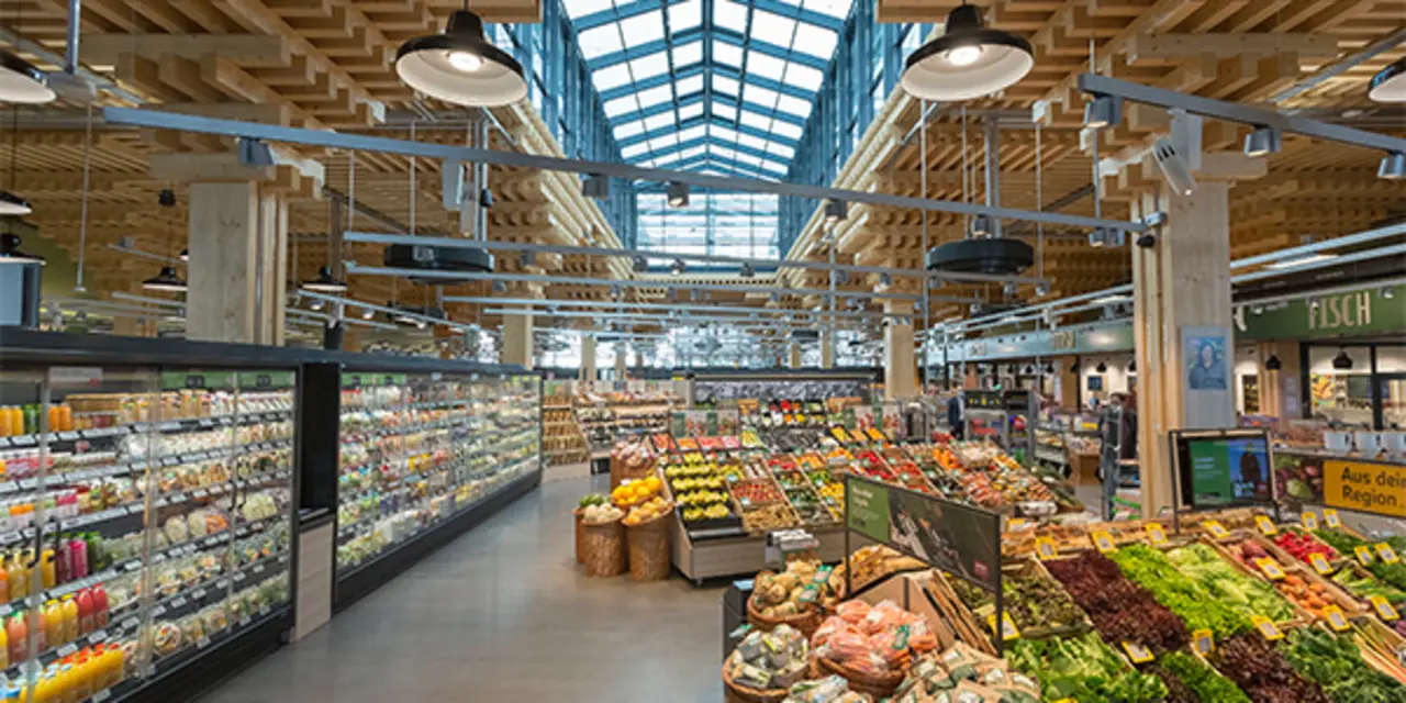 Der REWE Green Farming Markt in Wiesbaden-Erbenheim von innen. Man erkennt das Baumaterial Holz. Im Vordergrund ist die Obst- und Gemüseabteilung zu sehen.