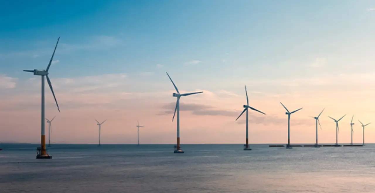 Ein Offshore-Windpark: Mehrere weiße Windräder stehen im Ozean.