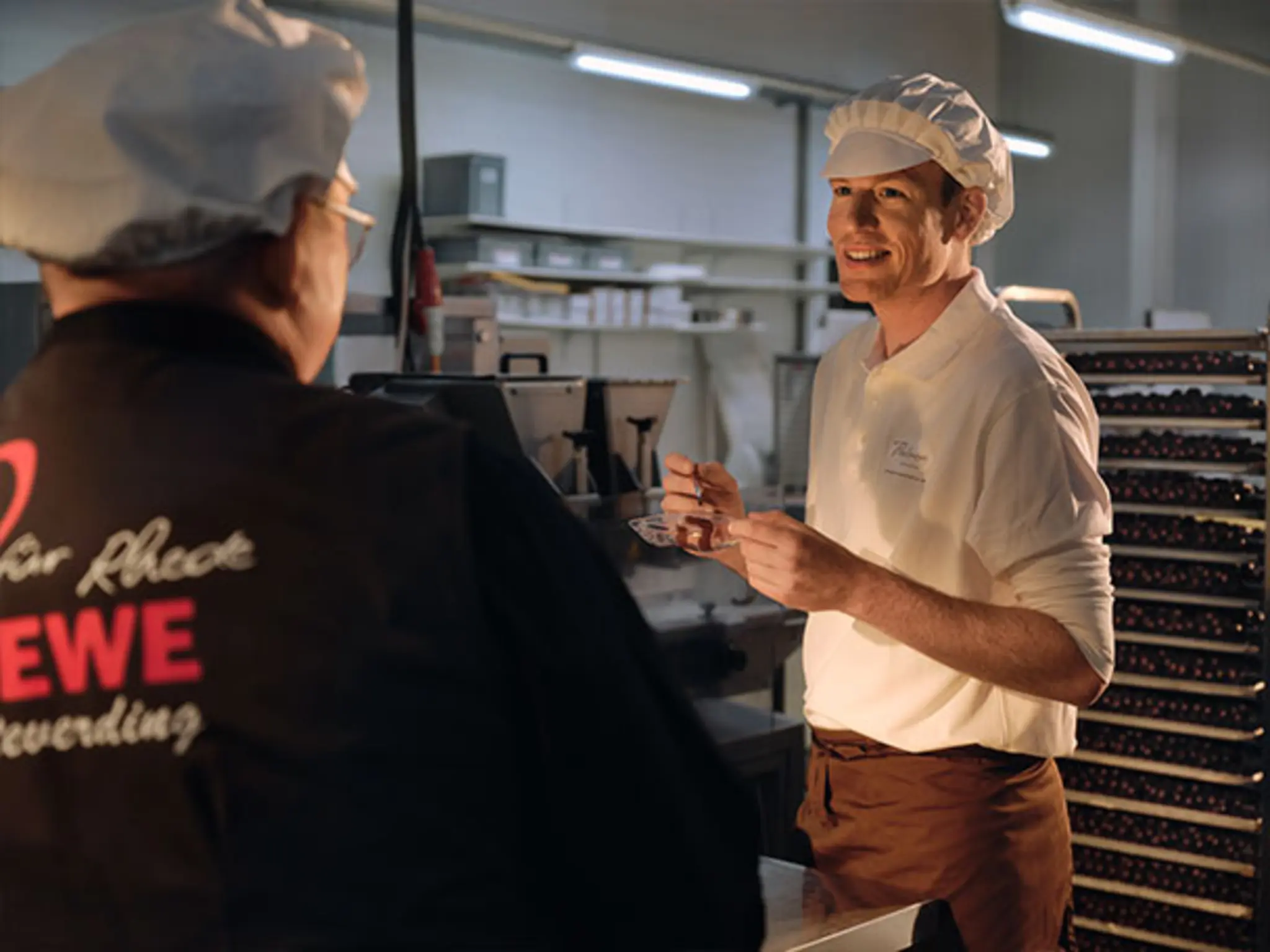 Pralinen-Hersteller Lukas Große-Bölting und REWE Kaufmann Christoph Steverding beim angeregten Gespräch in der Manufaktur. 