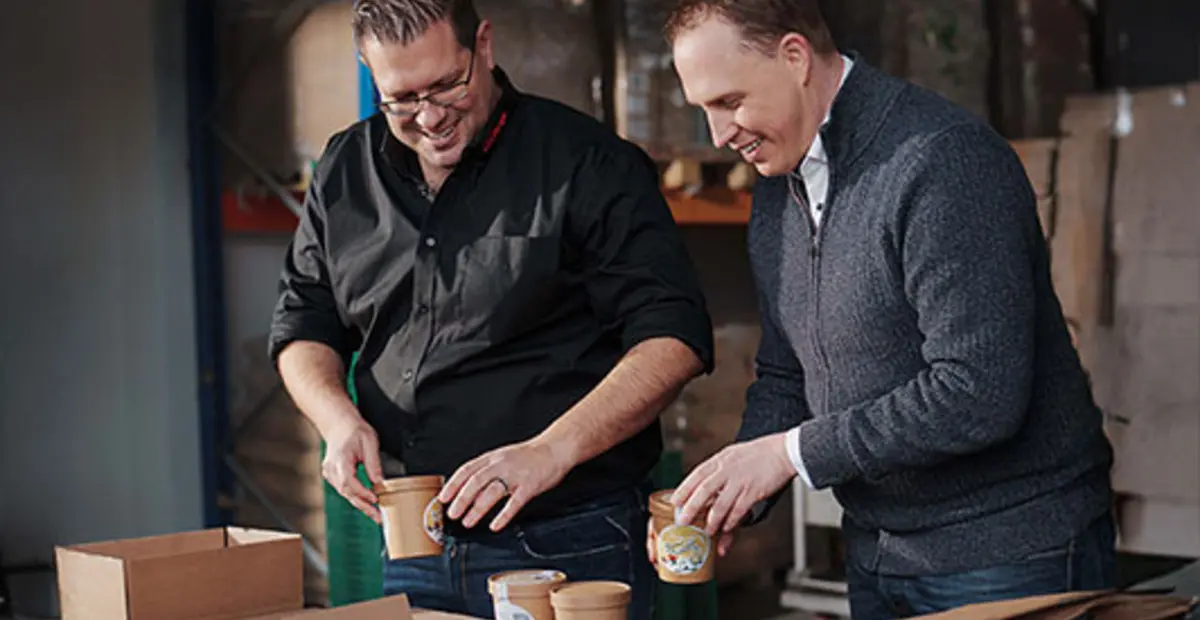 REWE Kaufmann Bernd Kaffenberger und Imker Sascha Greiner wählen gemeinsam Verpackungen für das Honig-Eis aus.