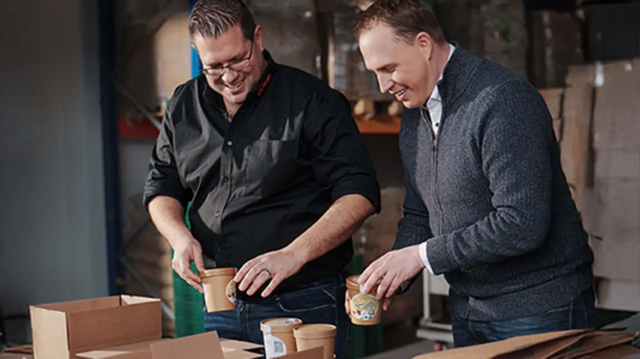 REWE Kaufmann Bernd Kaffenberger und Imker Sascha Greiner wählen gemeinsam Verpackungen für das Honig-Eis aus.