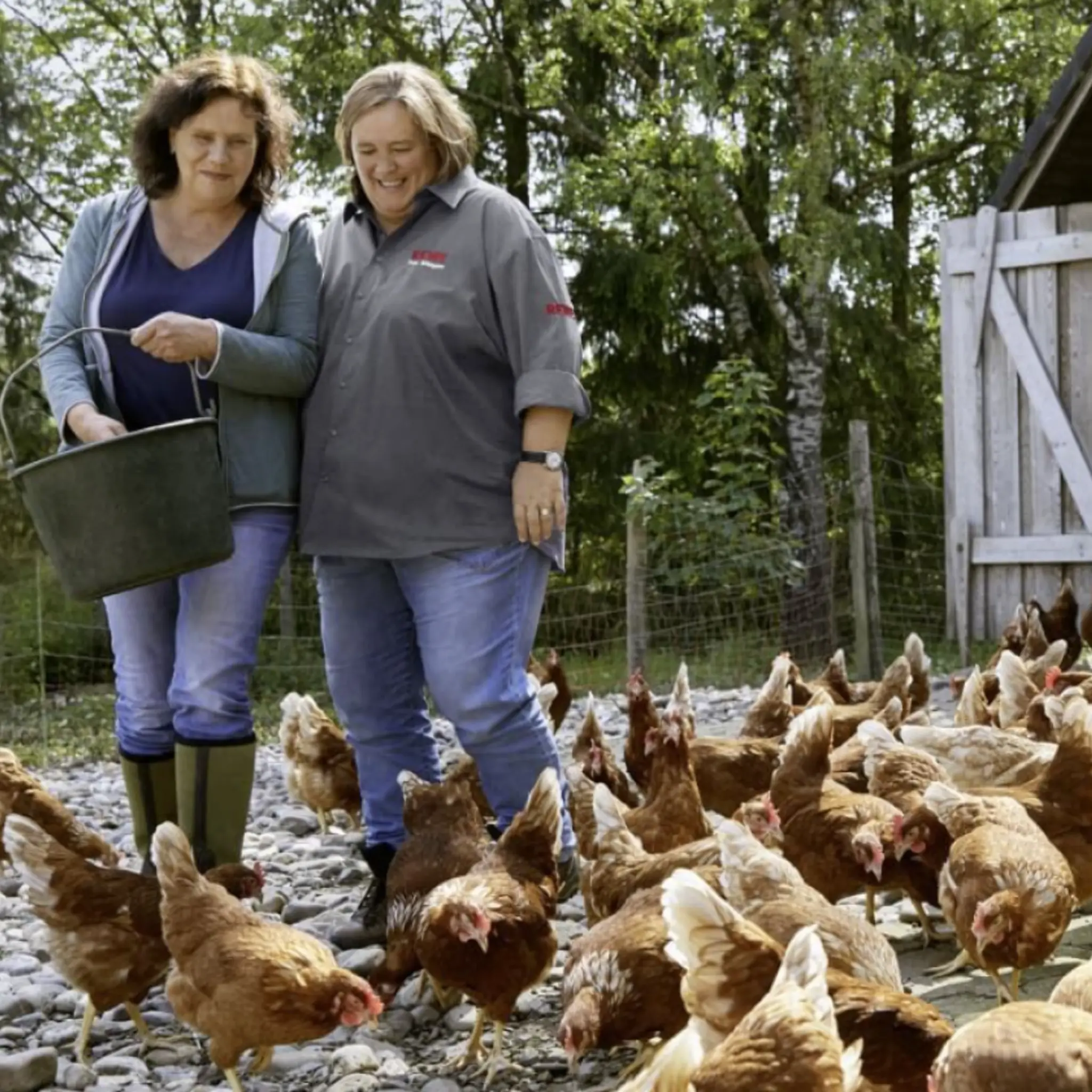 Mechthild Klose und REWE Kauffrau Ursula Wintgens füttern Mechthilds Hühner.