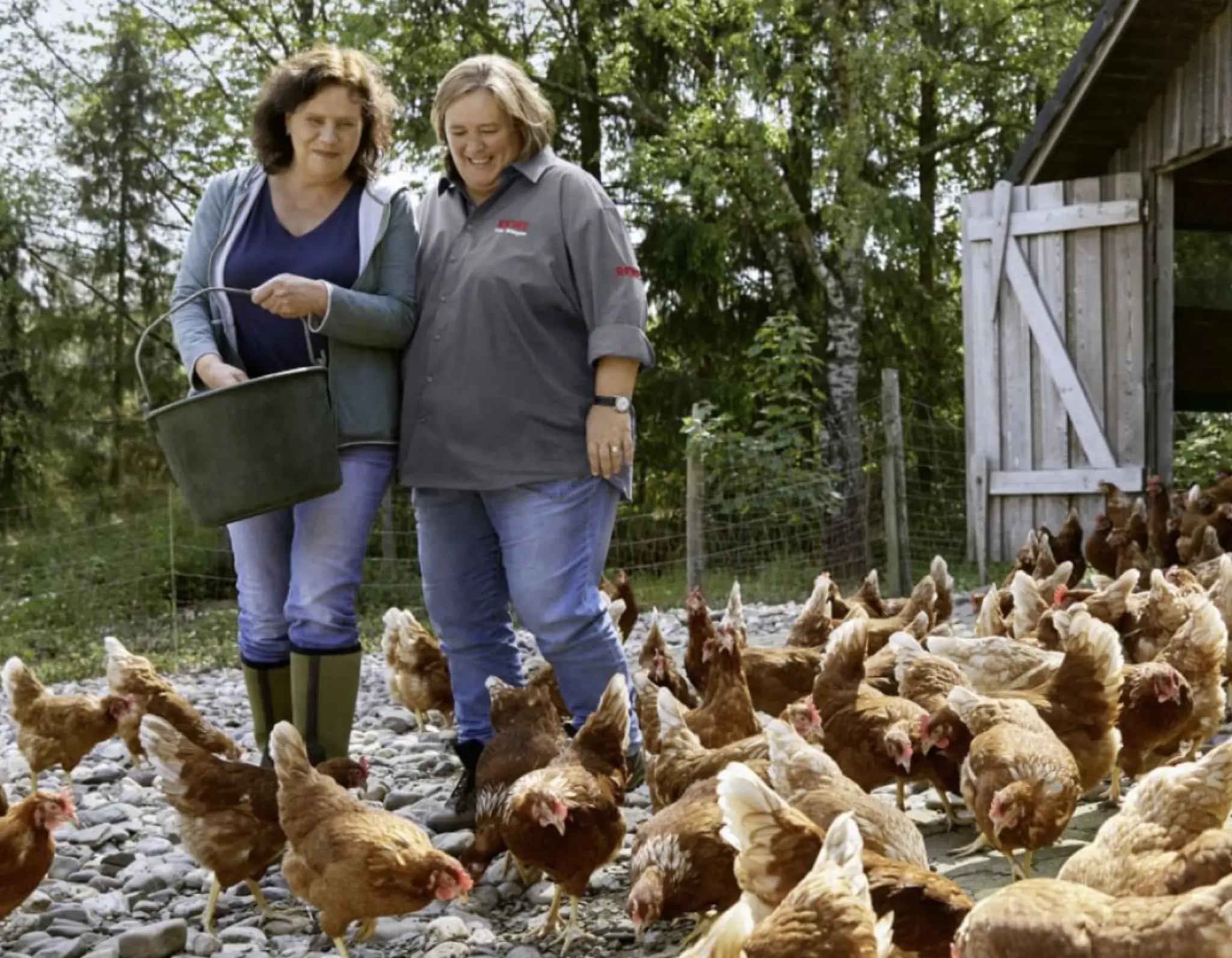 Mechthild Klose und REWE Kauffrau Ursula Wintgens füttern Mechthilds Hühner.