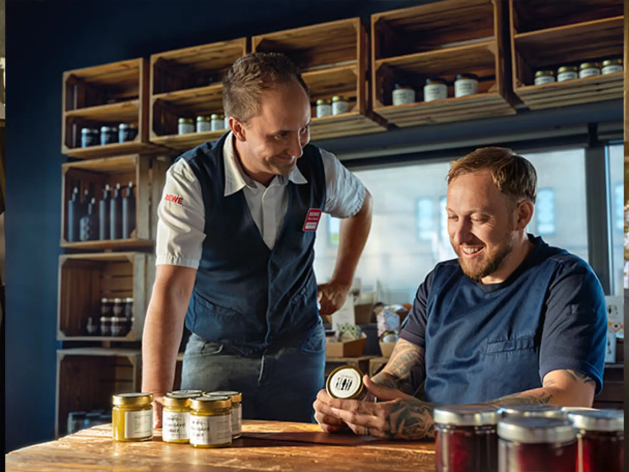 REWE Kaufmann Sascha Hansen und Spitzenkoch Mario Laabs in Marios Restaurant. Der Koch zeigt dem Kaufmann mehrere Gläser mit „Fienkost“.