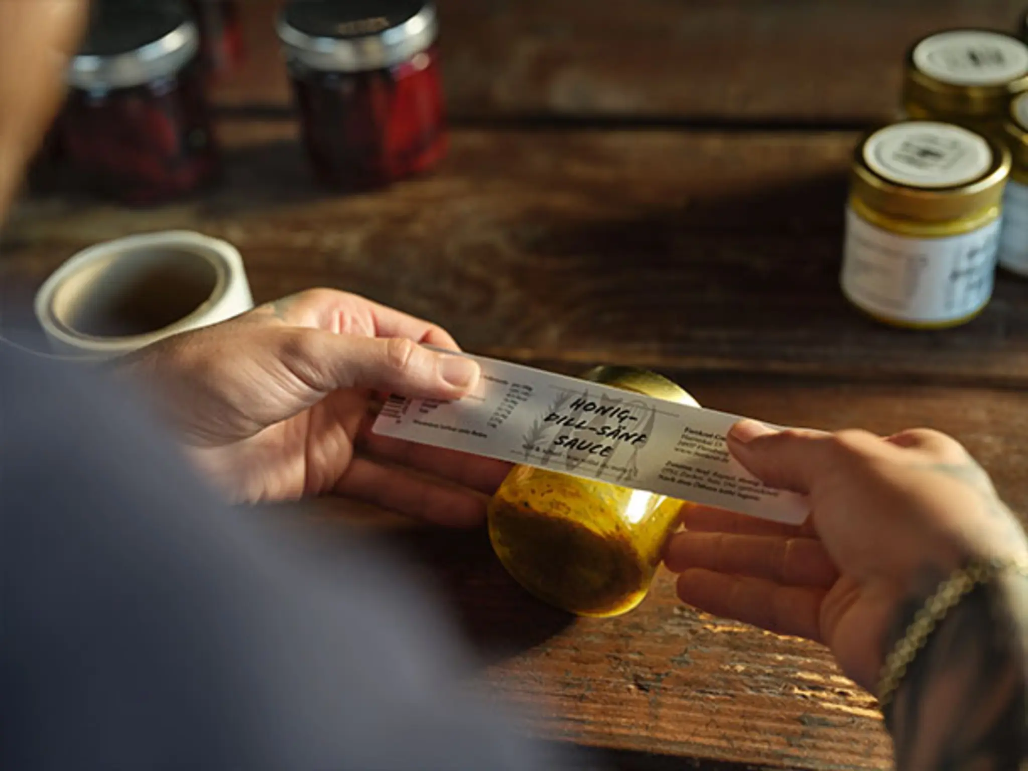 Mario Laabs klebt ein Etikett per Hand auf eines seiner „Fienkost“ Gläser. 