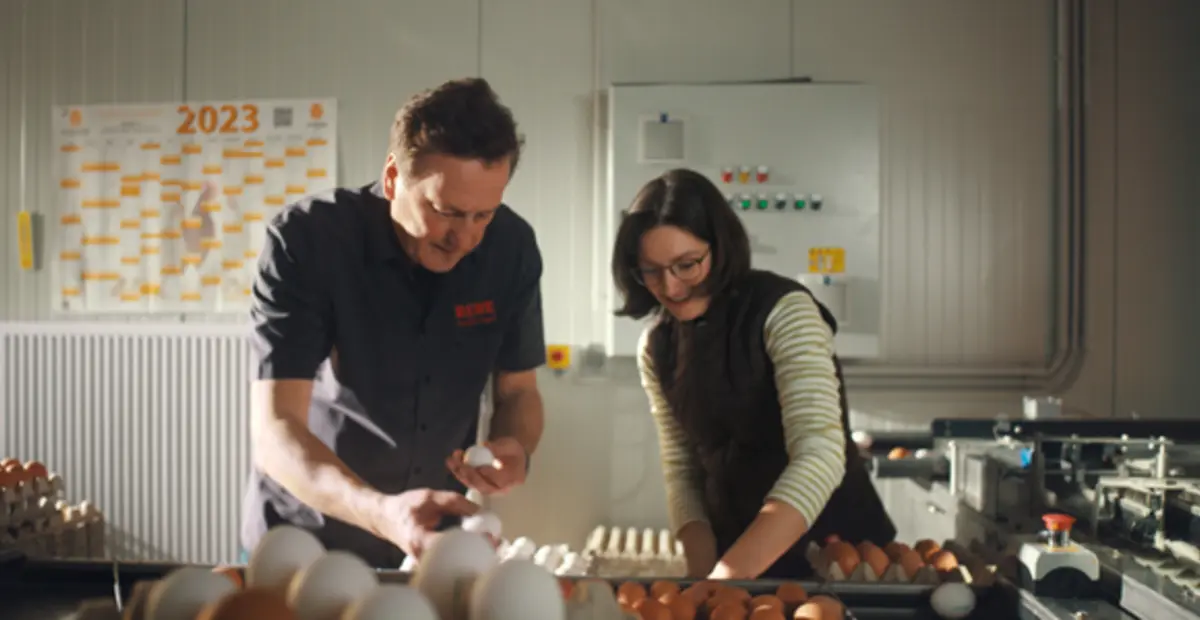 Patricia Keppler und REWE Kaufmann Elmar Engel sortieren Eier vom Hofgut Dettenberg.