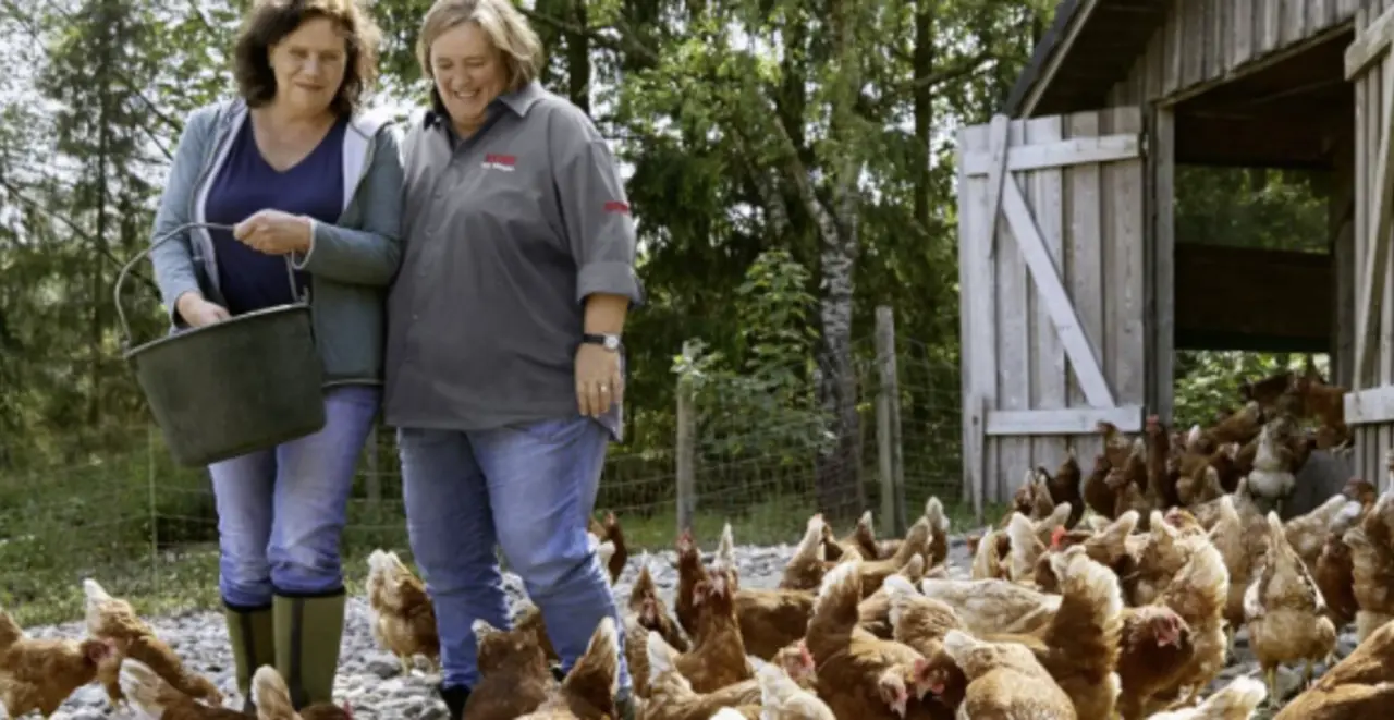Mechthild Klose und REWE Kauffrau Ursula Wintgens füttern Mechthilds Hühner.