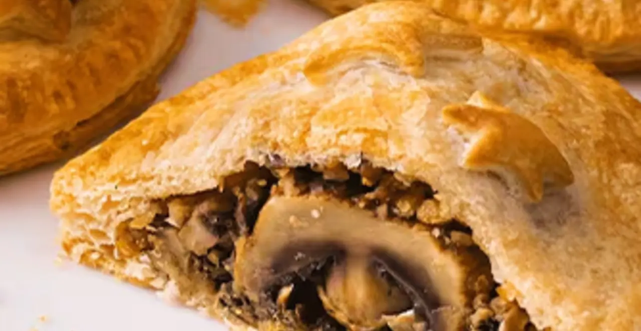 Ein Teller mit mehreren Stücken veganem Braten in Blätterteig. Ein Stück ist in der Mitte durchgeschnitten.