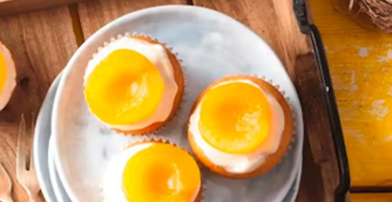 Ein Tablett mit veganen Spiegeleier-Muffins und Geschirr steht auf einem Tisch. 