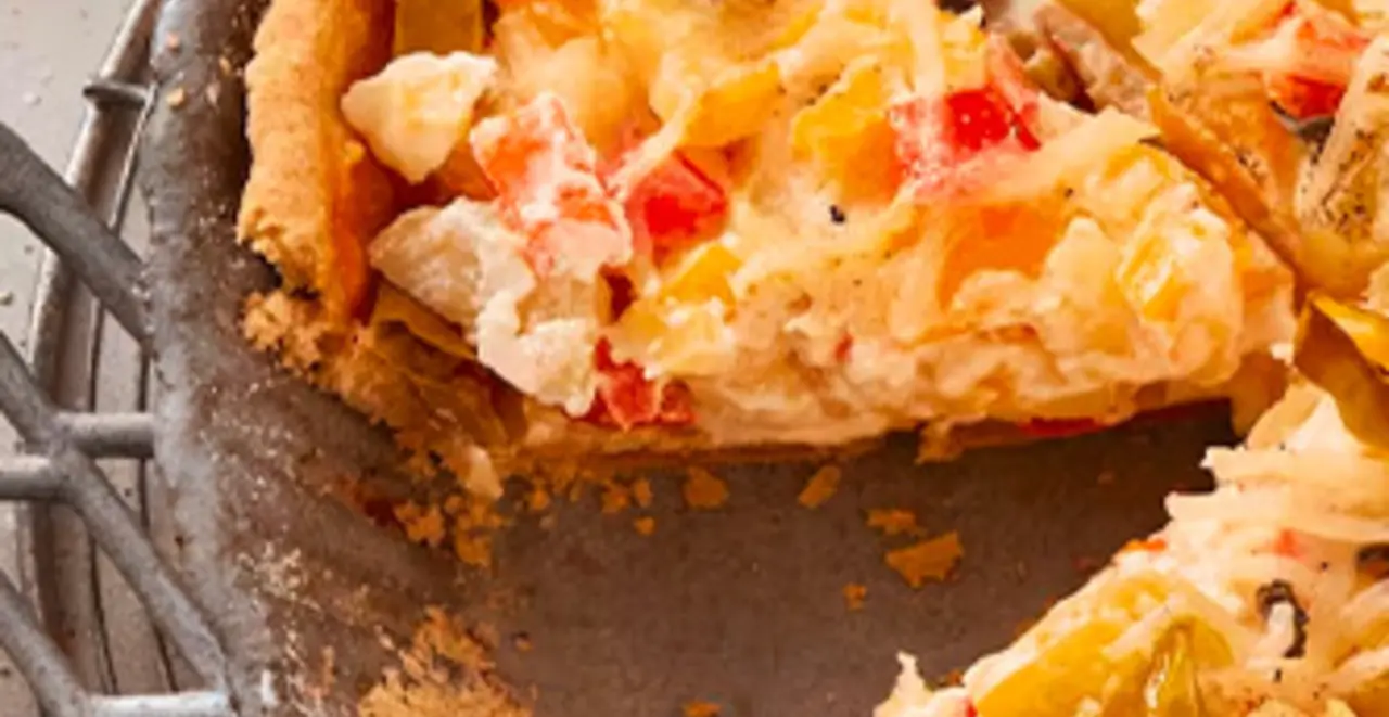 Ein veganer Kartoffelkuchen steht in der Kuchenform auf einem Tisch. Zwei Stücke fehlen schon.