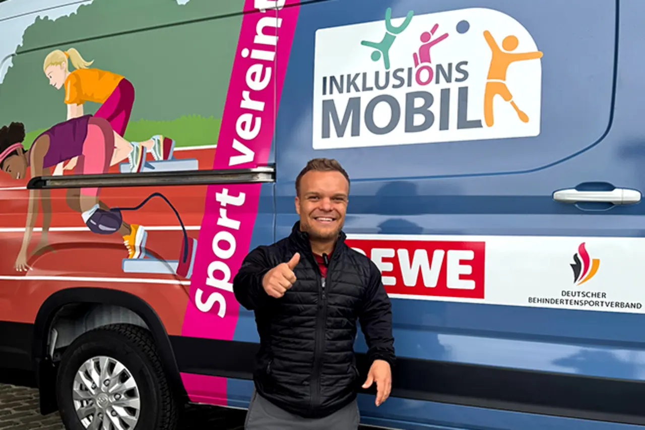 Botschafter und Para-Kugelstoßer Niko Kappel vor dem Inklusionsmobil. Er zeigt „Daumen hoch“.
