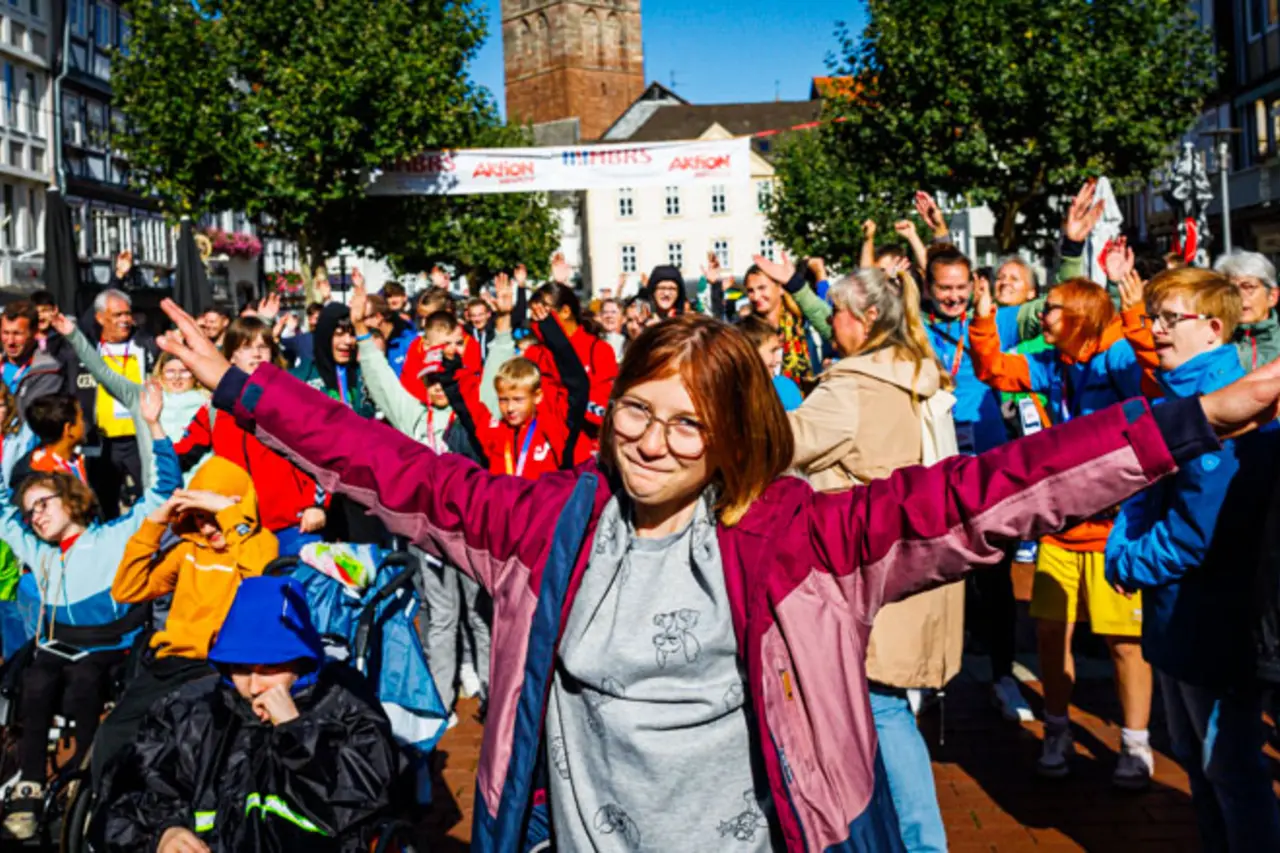 Viele Menschen mit und ohne Behinderung jubeln beim Event einer inklusiven Tanzgruppe zu.