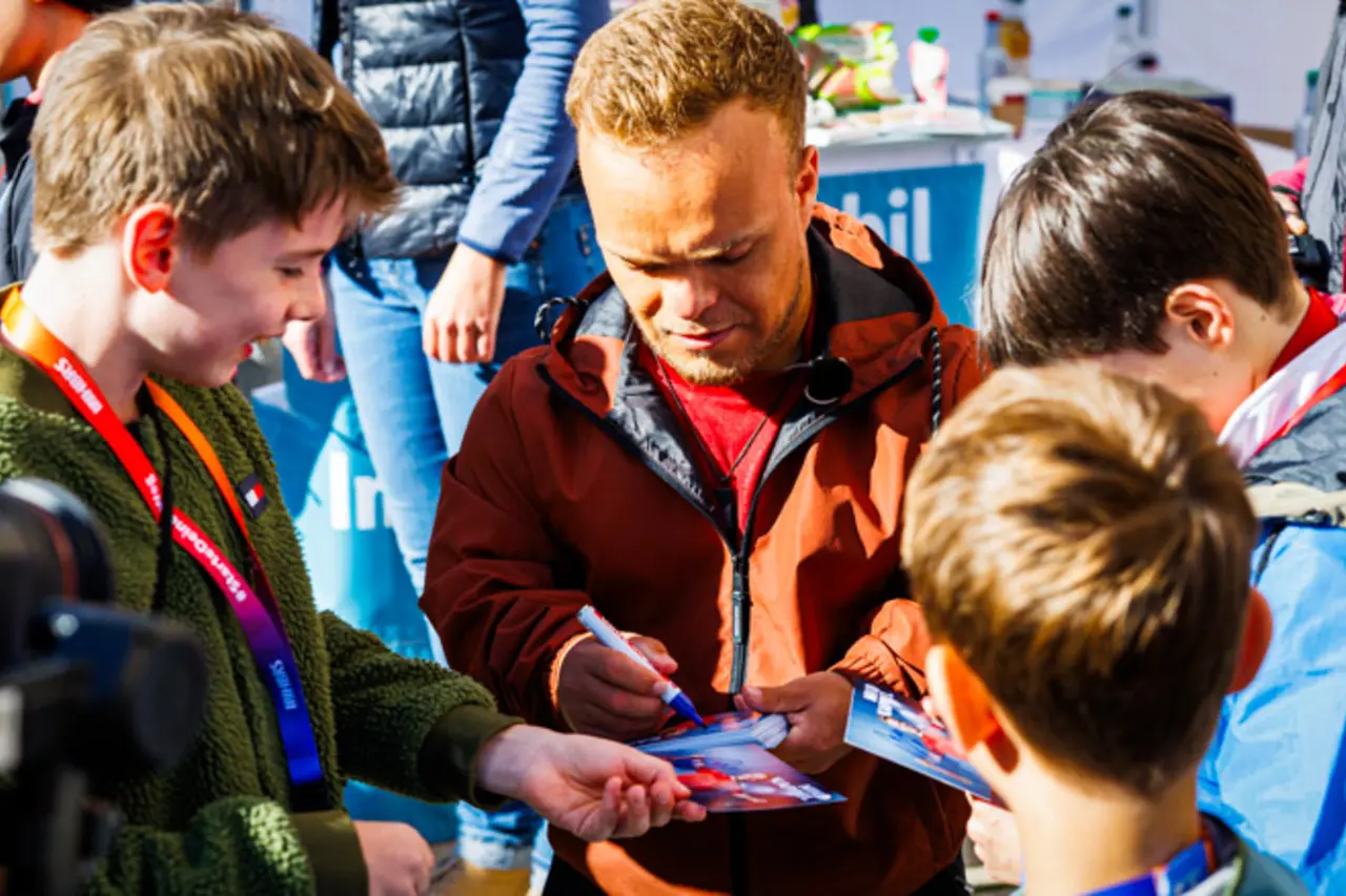 Paralympic-Kugelstoßer Niko Kappel gibt Kindern mit und ohne Behinderung Autogramme.