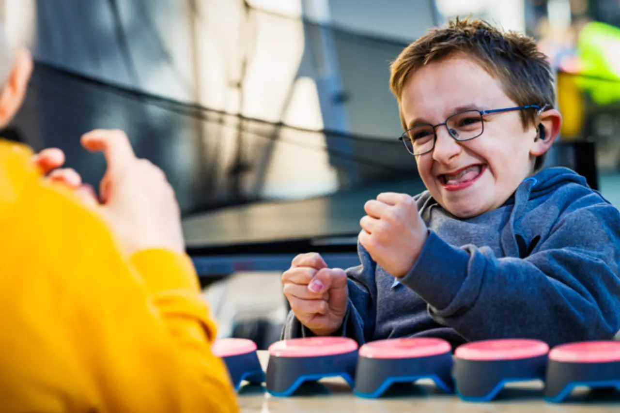 Ein Kind mit Behinderung jubelt über einen Erfolg bei einem inklusiven Spiel.