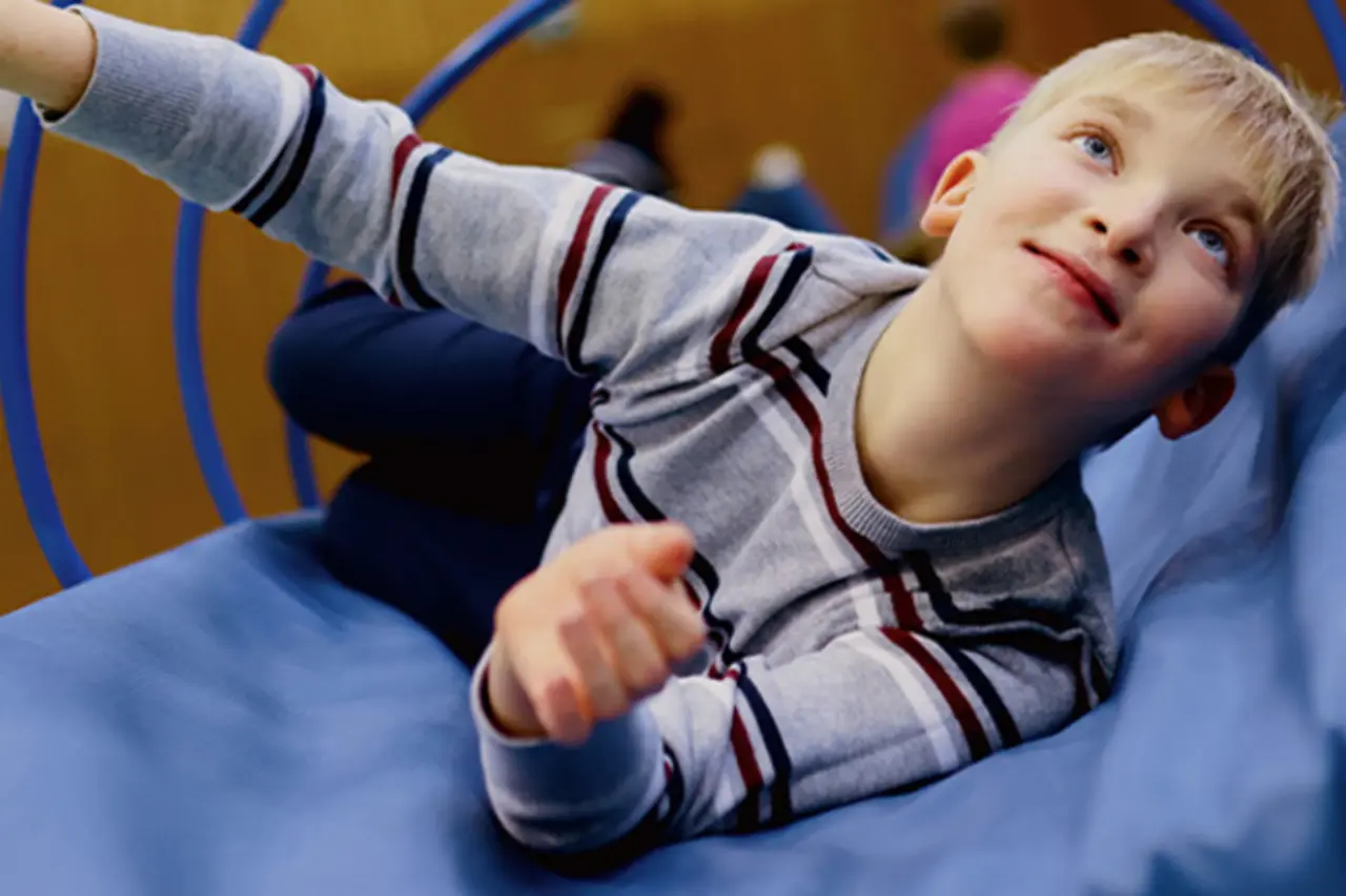 Ein Kind turnt in einer spielerischen Gerätelandschaft.