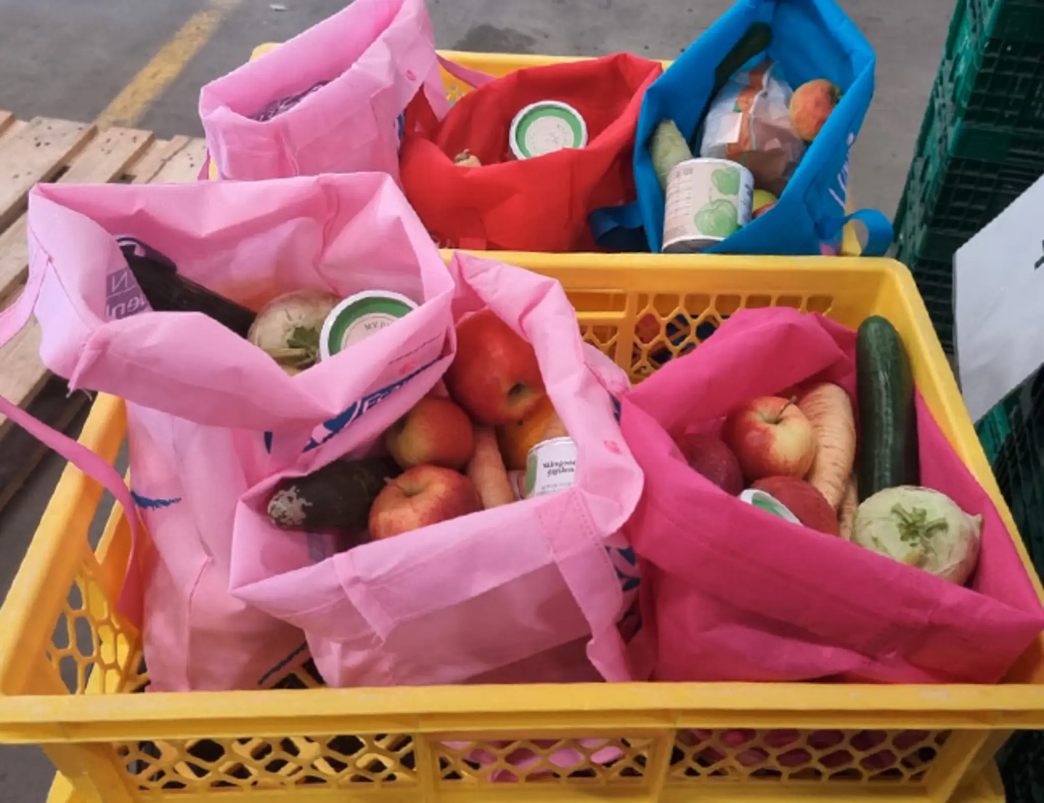Man sieht eine Kiste mit mehreren gepackten Lebensmittel-Tüten die an Bedürftige verteilt werden.
