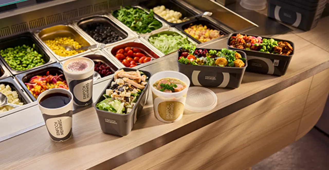 Verschiedene Mehrweg-Pfandbehälter stehen an der Salattheke in einem REWE Markt.