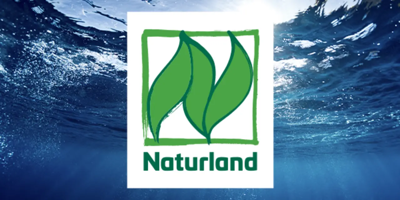 Das Naturland Siegel vor einem Meer im Hintergrund.