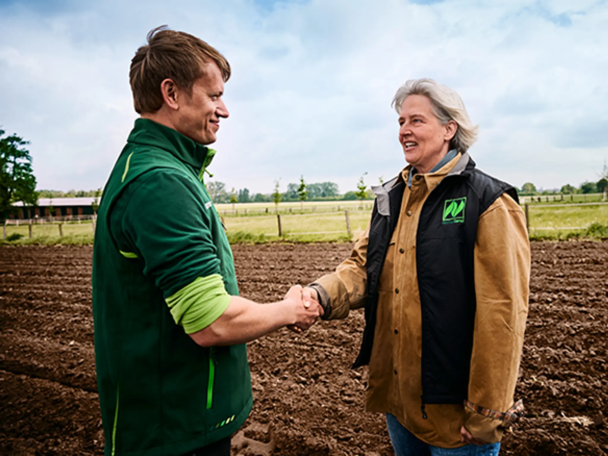 Eine Naturland Expertin und ein Landwirt bei einem Beratungstermin auf dem Feld.